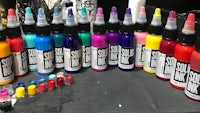 a variety of colored ink bottles on a table