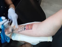 a woman getting a tattoo on her arm