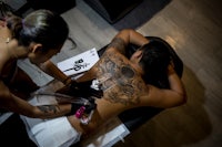 a man getting tattooed on his back