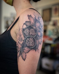 a woman with a tattoo of flowers and chinese characters